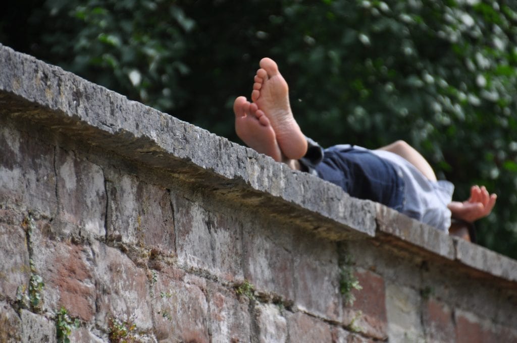 Siesta - Mensch schläft auf einer Mauer